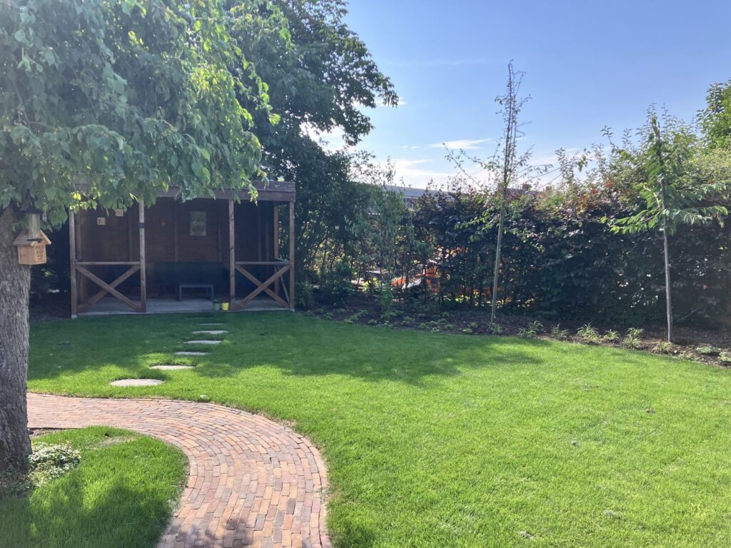 Tuin met gazon en gebakken klinkers