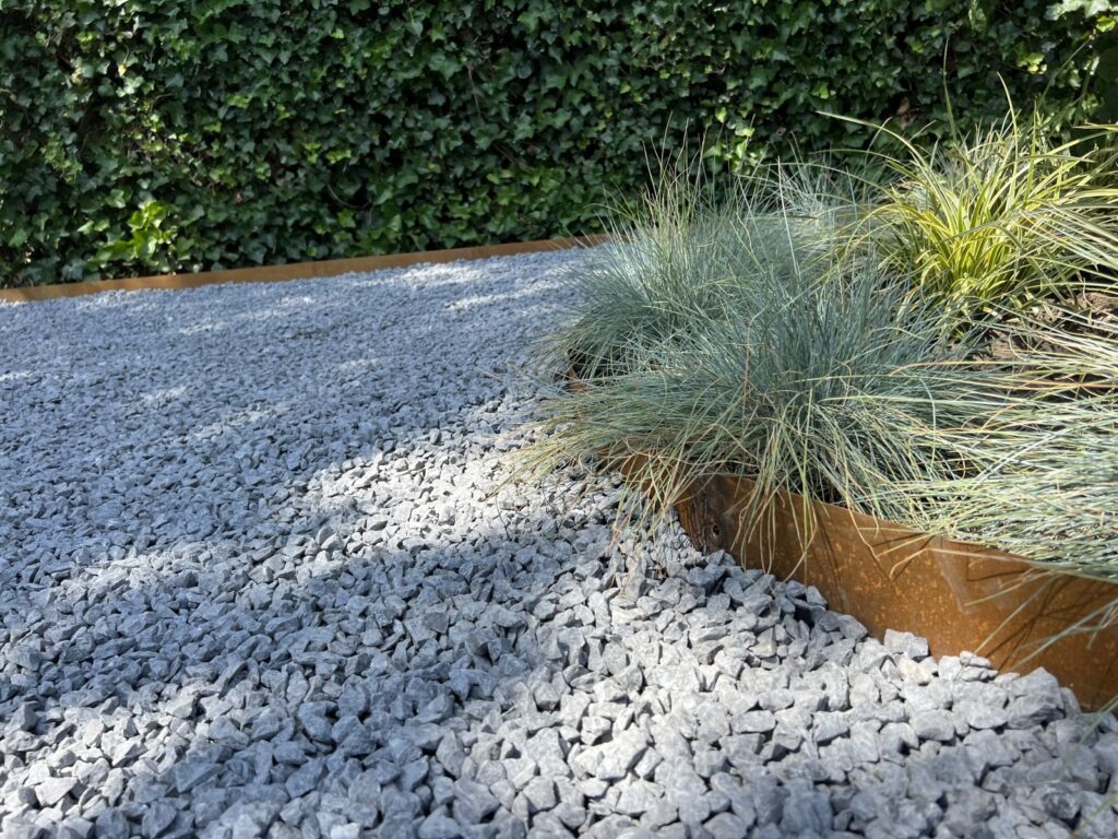 Cortenstalen borderrand met siergrassen en grind in moderne tuin in Barneveld